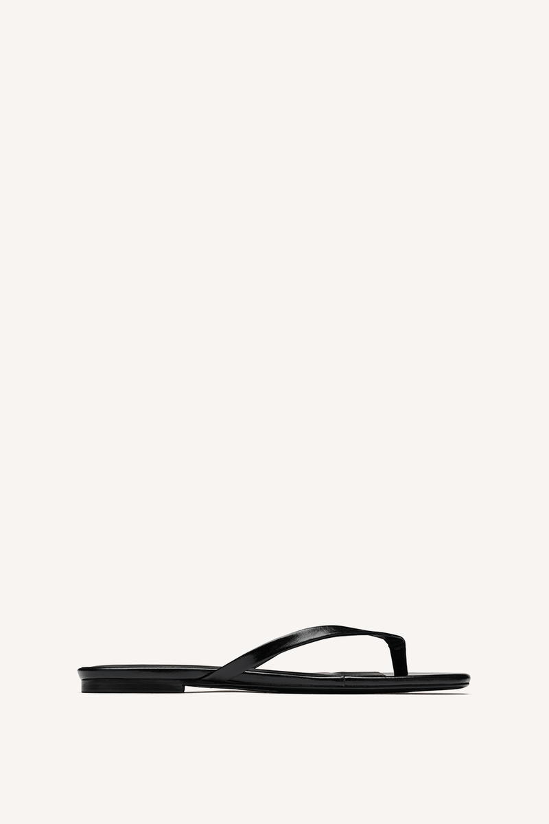Nelson Made black leather thong sandal with a flat sole, shown in profile against a solid off-white background.