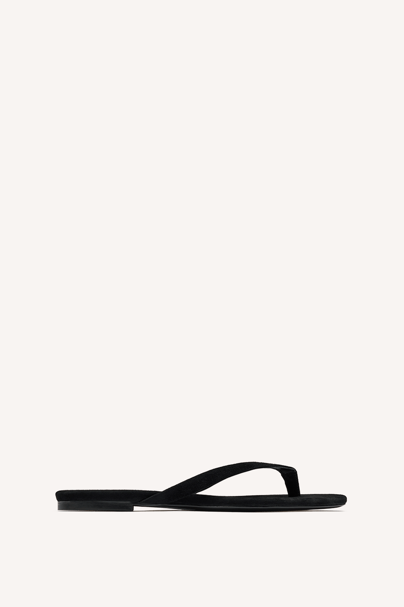 Nelson Made black thong sandal with a flat sole and thin straps, shown in profile against a solid off-white background.